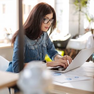 Confident self employed woman looking at her insurance needs on a computer