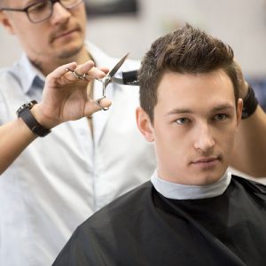 Portrait Of Handsome Young Man Getting Haircut