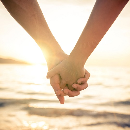 Couple Holding Hands At Sunset