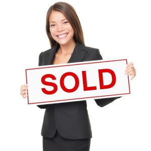 Real estate agent holding sold sign isolated on white background.